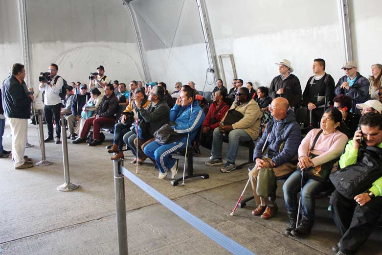 Personas con discapacidad visual tocando placas conmemorativas de la candelaria 