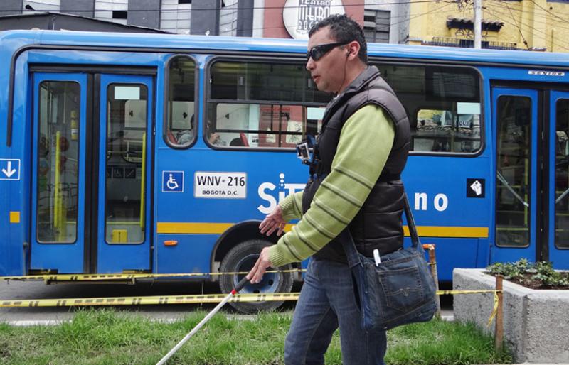 Persona con discapacidad visual en un paradero del SITP