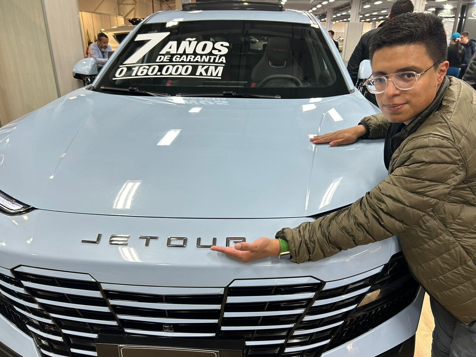 Daniel cortes está frente a una Jetour él señala la marca y el capó