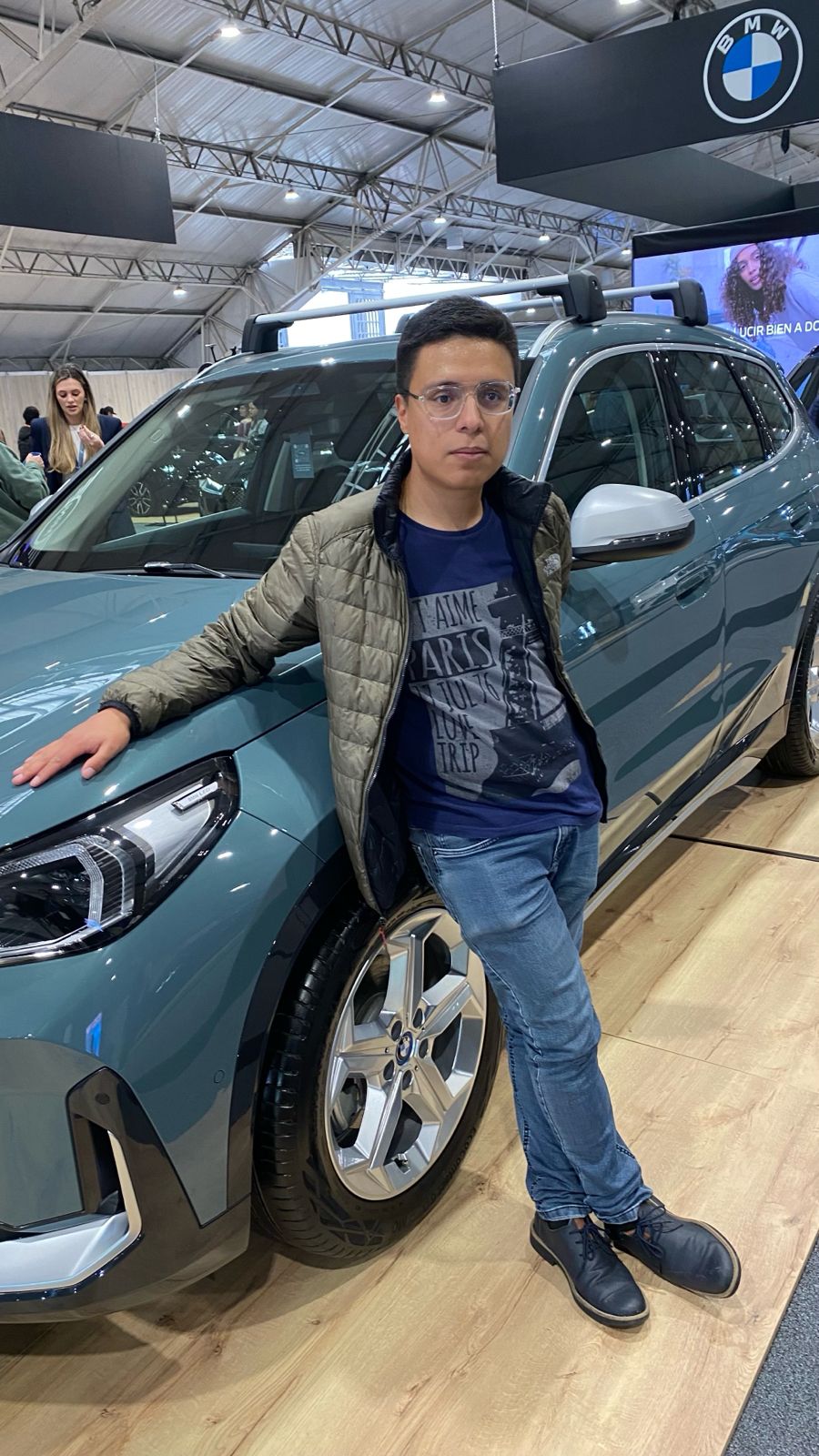 Daniel está apoyado sobre una SUV  BMW