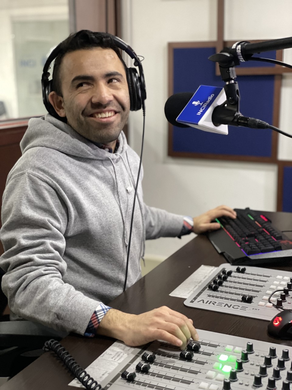 Foto de carlos quintero frente a la consola de la emisora, el sonrie 