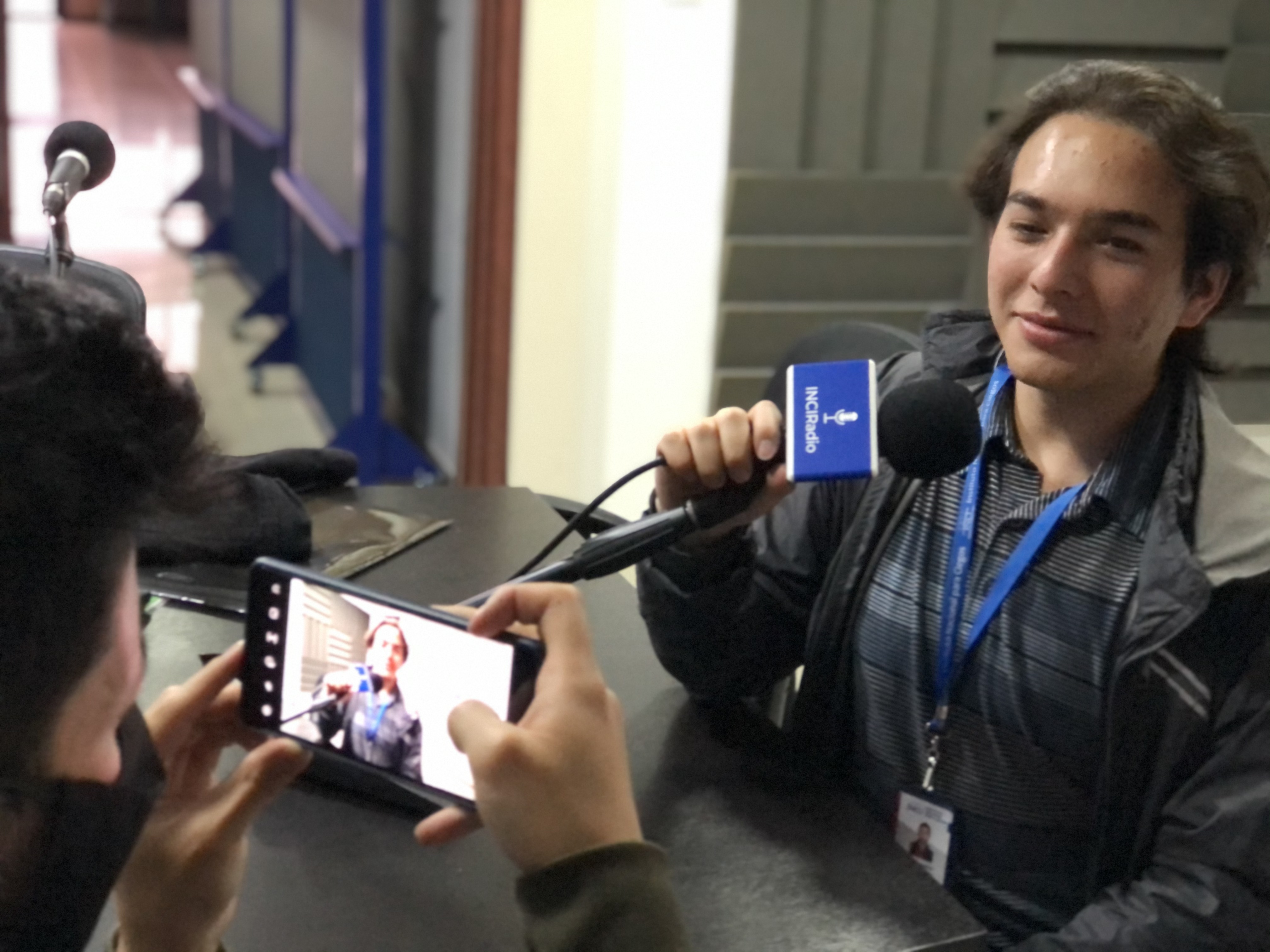 Imagen de Camilo Garnica, en la foto se ven las manos de Nicolás quién sostiene un celular en sus manos,  él está tomando una foto de camilo, en el celular se ve el rostro de camilo