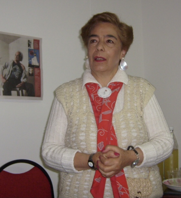 Imagen de Edda ella tiene sus manos entrelazadas, viste un buzo de calor blanco y una bufanda de color rojo