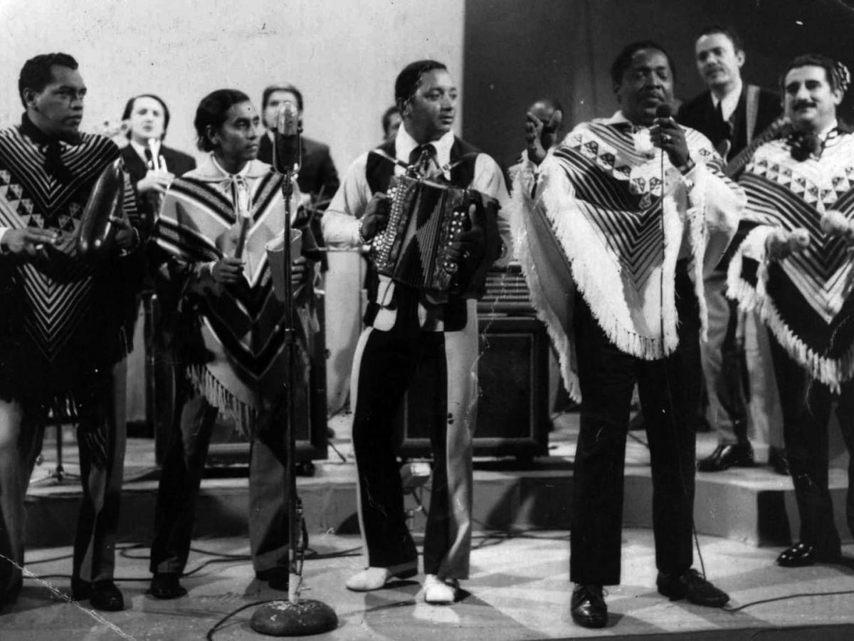 los corraleros de majagual en vivo, todos visten ponchos y están en una presentación cada integrante tiene su instrumento musical