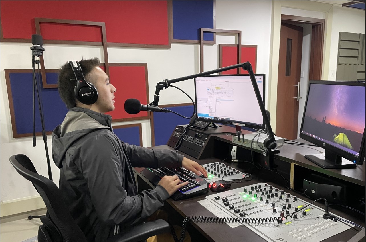 Foto de Camilo garnica  frente a la consola de la emisora grabando mañanas inci de lunes,  con sus manos está operando la consola
