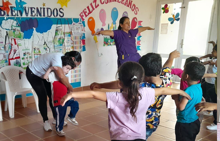 Docentes interactuando y enseñándole a un niño con discapacidad visual