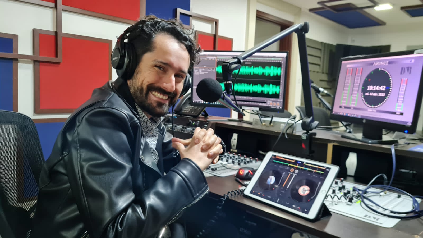 Foto de Henry Díaz Frente a la consola de INCIRadio, él sonríe, la imagen se tomó realizando el programa Mañanas INCI