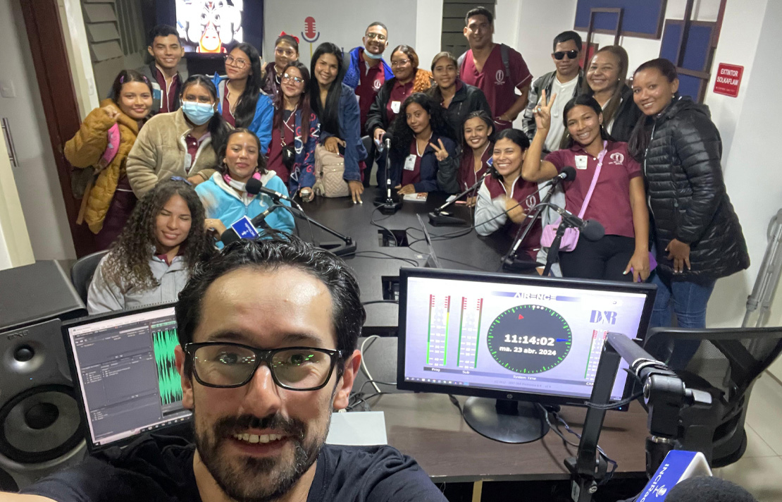 Henry Díaz, acompañado por varios estudiantes en la cabina de INCIRadio