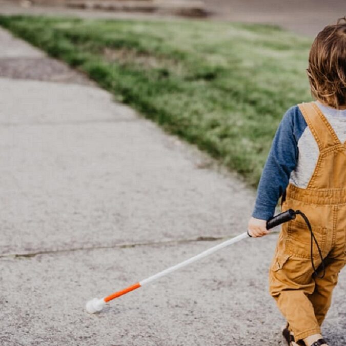un niño camina con su bastón 