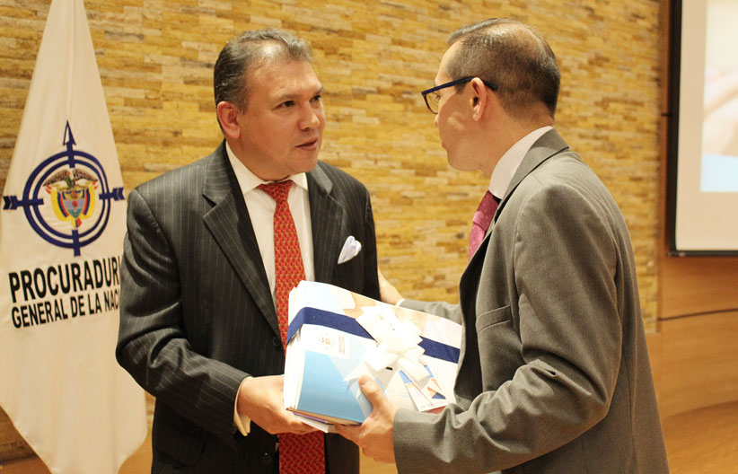 Fotografía, Carlos parra dussan recibiendo de parte de la procuraduria la ley 1712 en braille