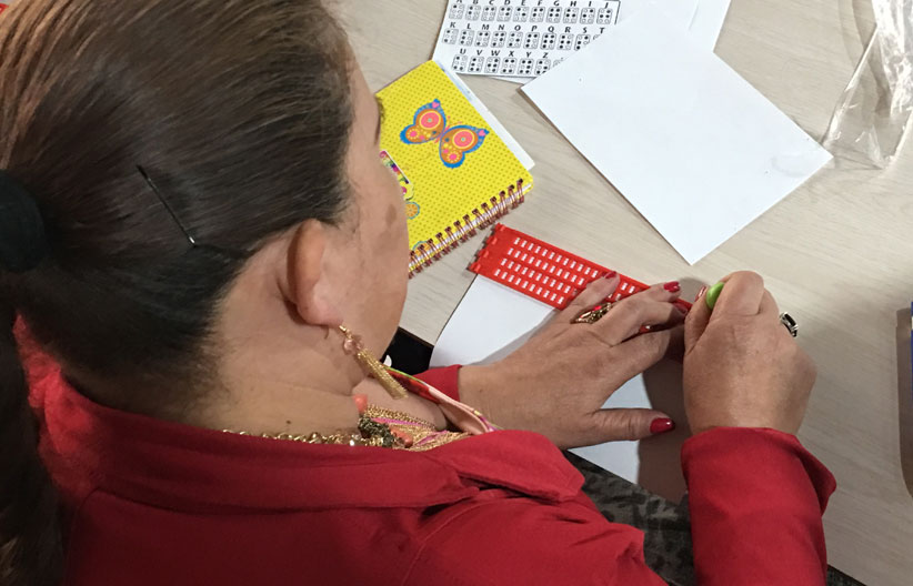 Estudiante con punzón y regleta
