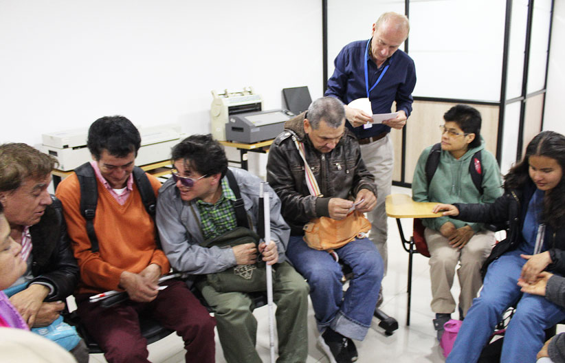 Fotografía, funcionarios centro cultural repartiendo el material didactico del taller
