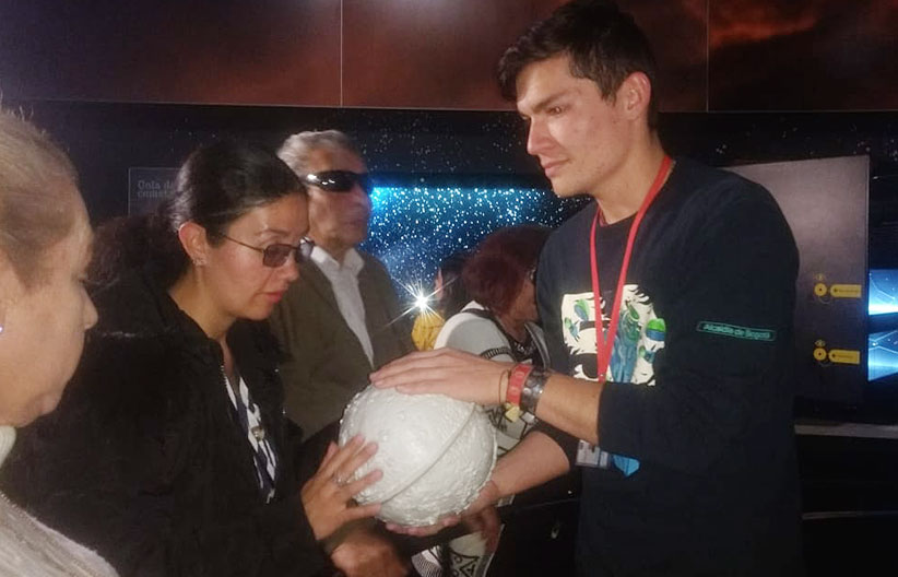 Personal del planetario enseñando planetas del sistema solar a escala