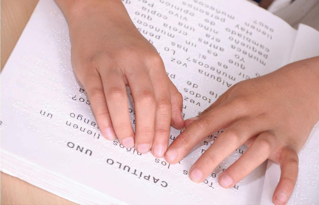 Persona con discapacidad visual leyendo un cuento en braille