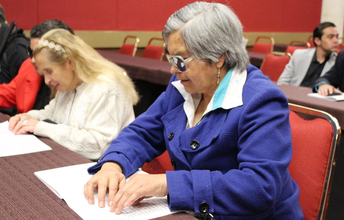 Fotografía, persona con discapacidad visual leyendo en braille