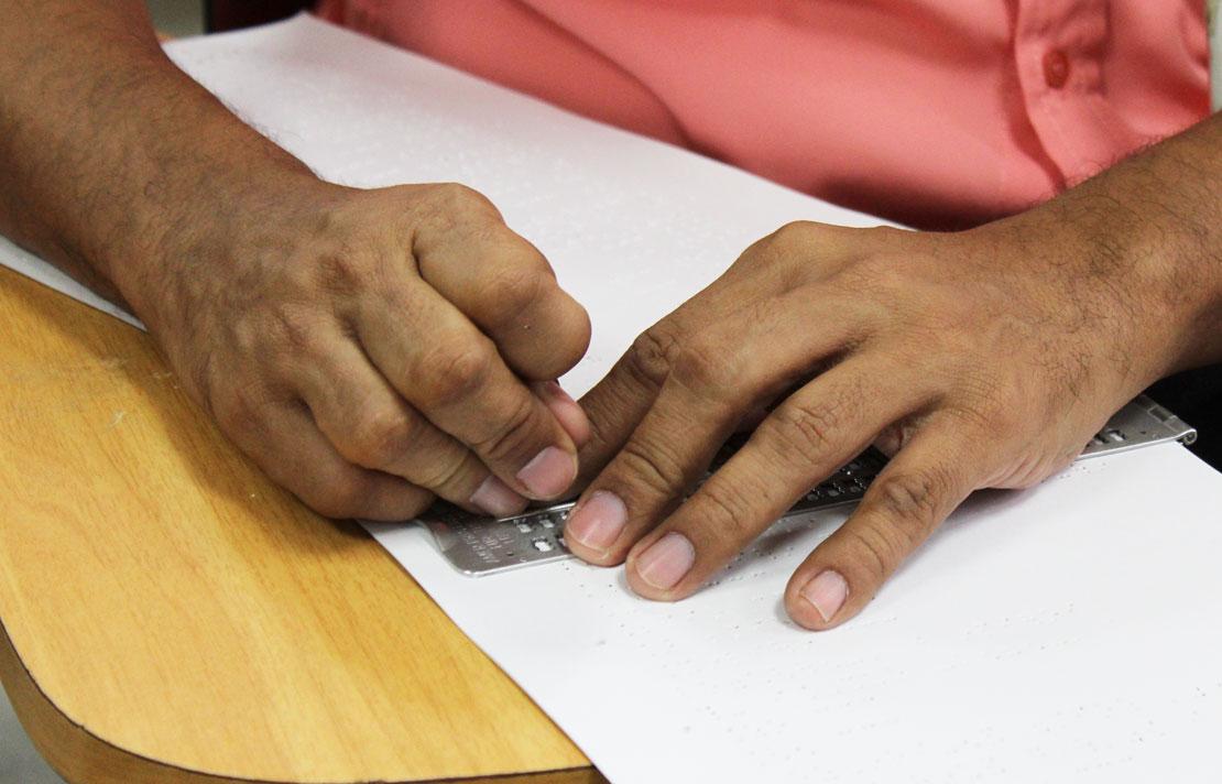 Persona con discapacidad visual escribiendo en braille