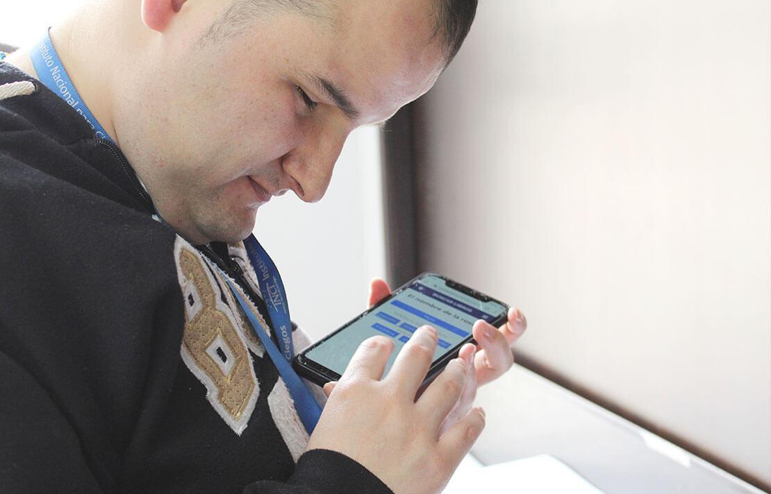 Persona con discapacidad visual interactuando con la aplicación de la biblioteca INCI