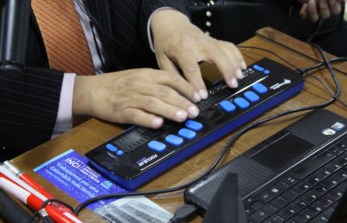 Fotografía - Persona con discapacidad visual utilizando teclado táctil en un computador portátil