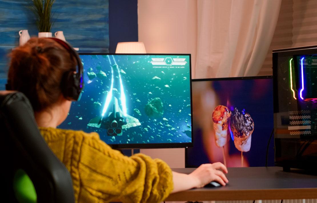 Mujer utilizando un video juego en su computador de escritorio