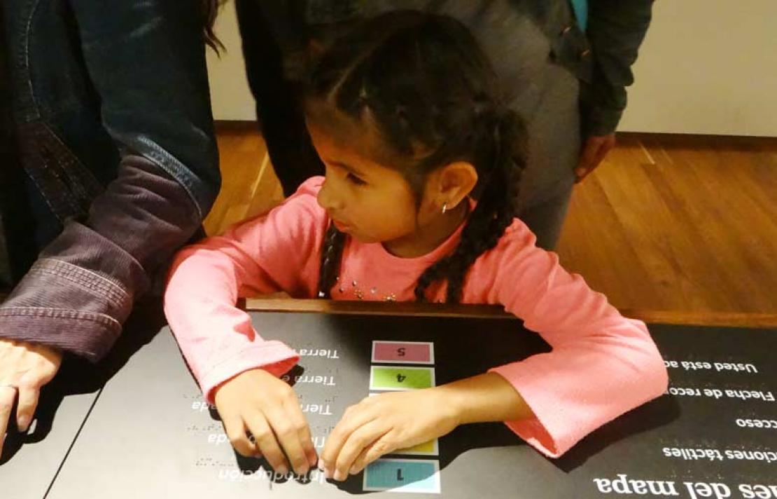 Personas con discapacidad visual, leyendo braille en una ficha técnica 