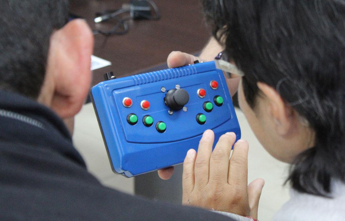 Fotografía, personas con discapacidad visual manipulando tecnologías en braille