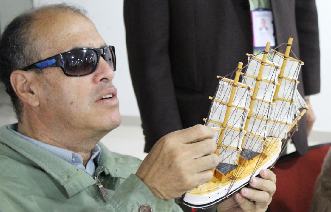 Fotografía, Persona con discapacidad visual con un modelo a escala de un barco