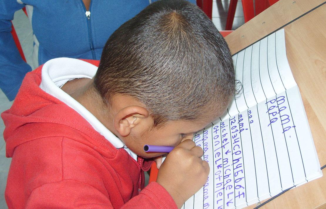 Niño de baja visión aprendiendo a escribir