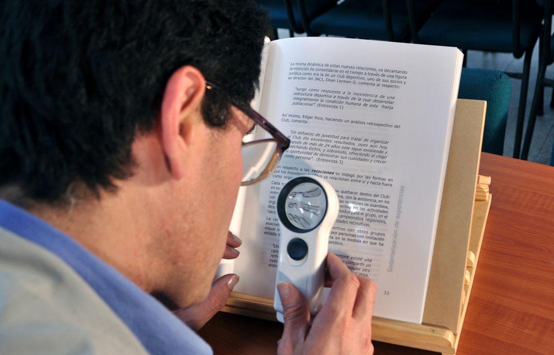 Fotografía, Persona con discapacidad visual leyendo con una lupa