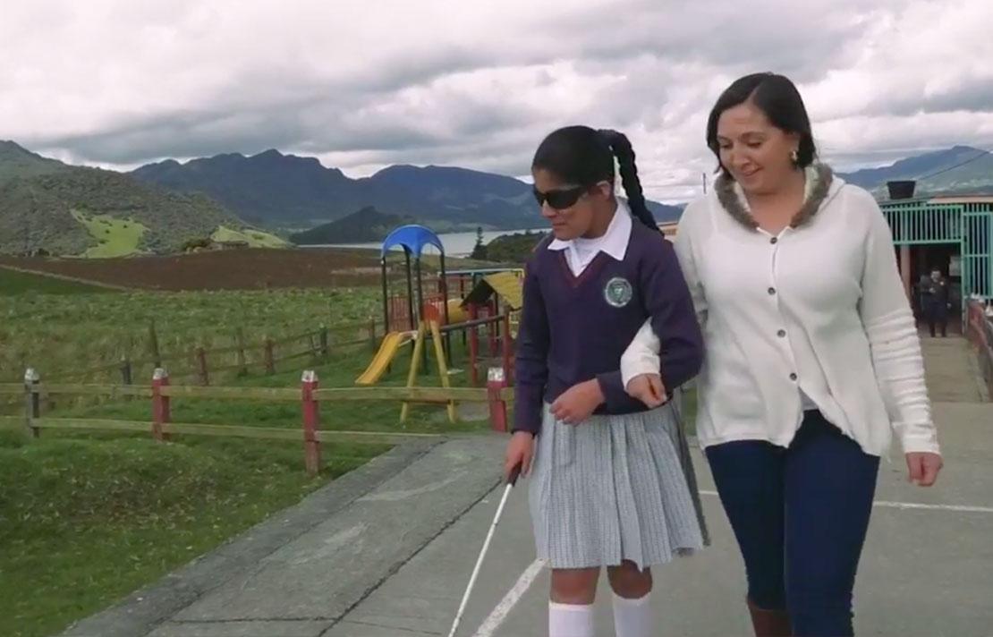 Fotografía, docente con una estudiante con discapacidad visual