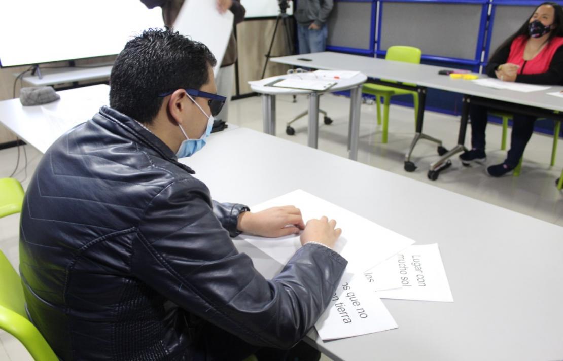 alejandro pabon está con sus dedos leyendo un texto en braille