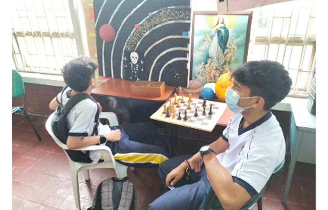Fotografía - Niños estudiantes en salón de clases sentados jugando ajedrez