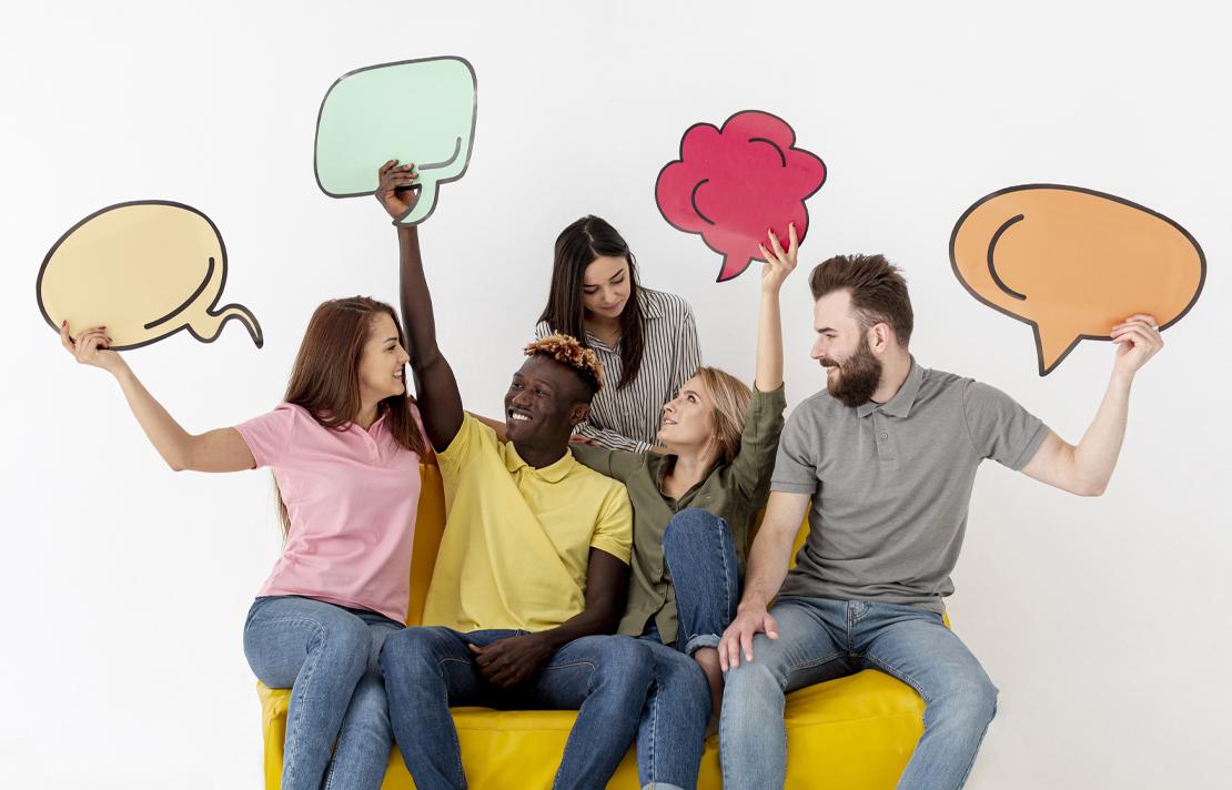 Grupo de personas sosteniendo viñetas de comics haciendo alusión a estar conversando