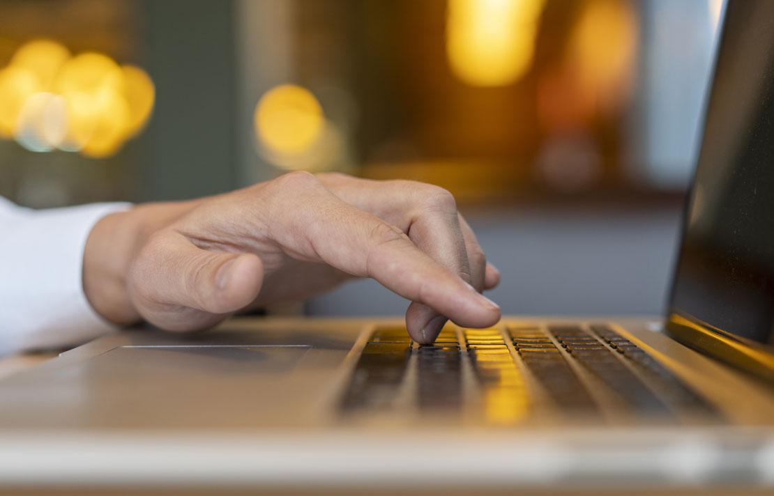 Hombre escribiendo en la computador portátil