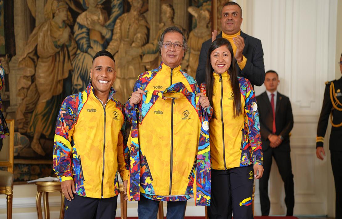 el presidente de la republica el doctor Gustavo Petro junto a dos de los abanderados paralímpicos sonríen