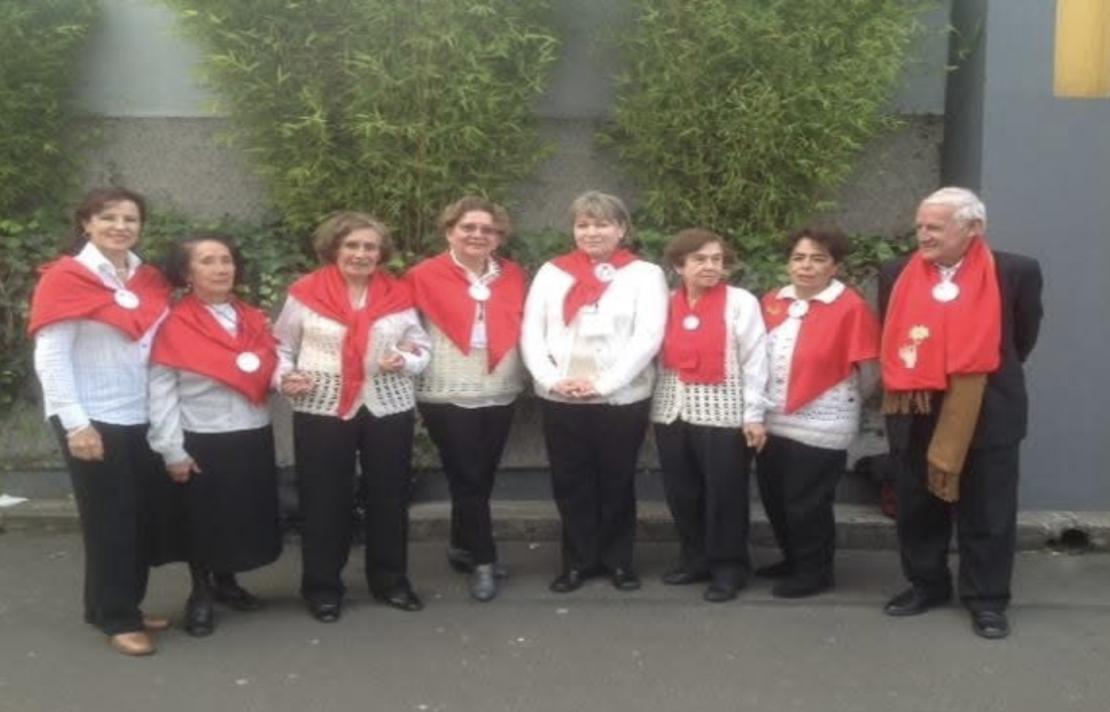 El equipo de la tertulia literaria del 2022, ellos visten un pantalón negro camisa blanda y bufanda roja, hay 7 mujeres y un hombre