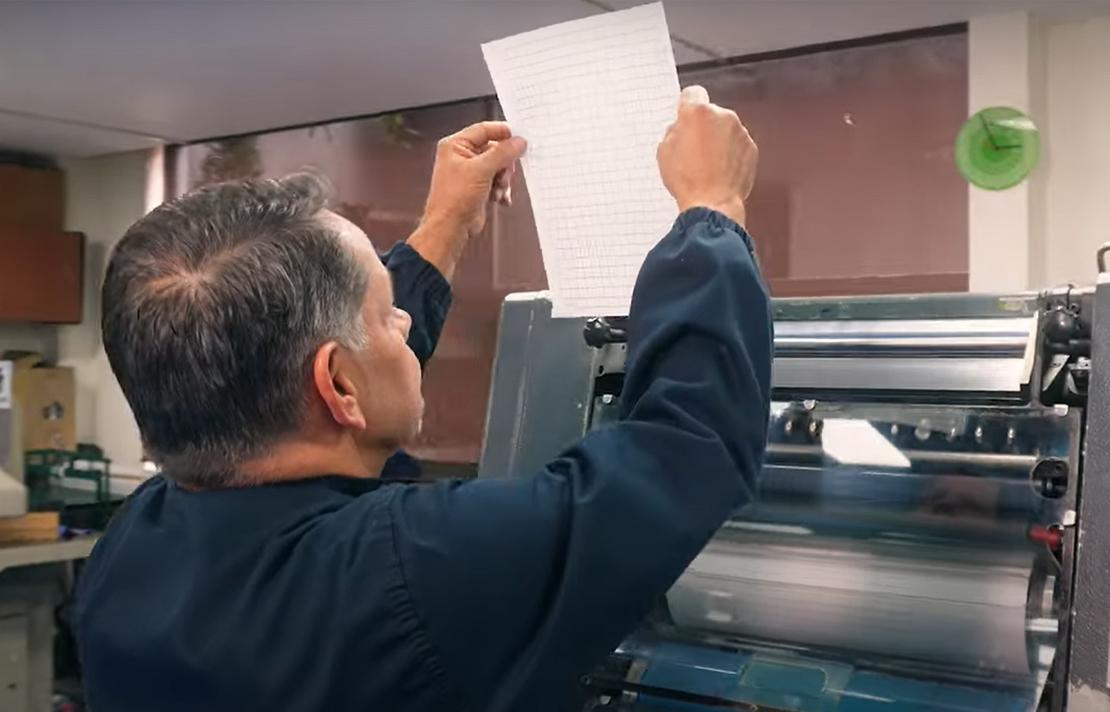 Operario de la Imprenta Nacional para ciegos verificando la calidad de una impresión