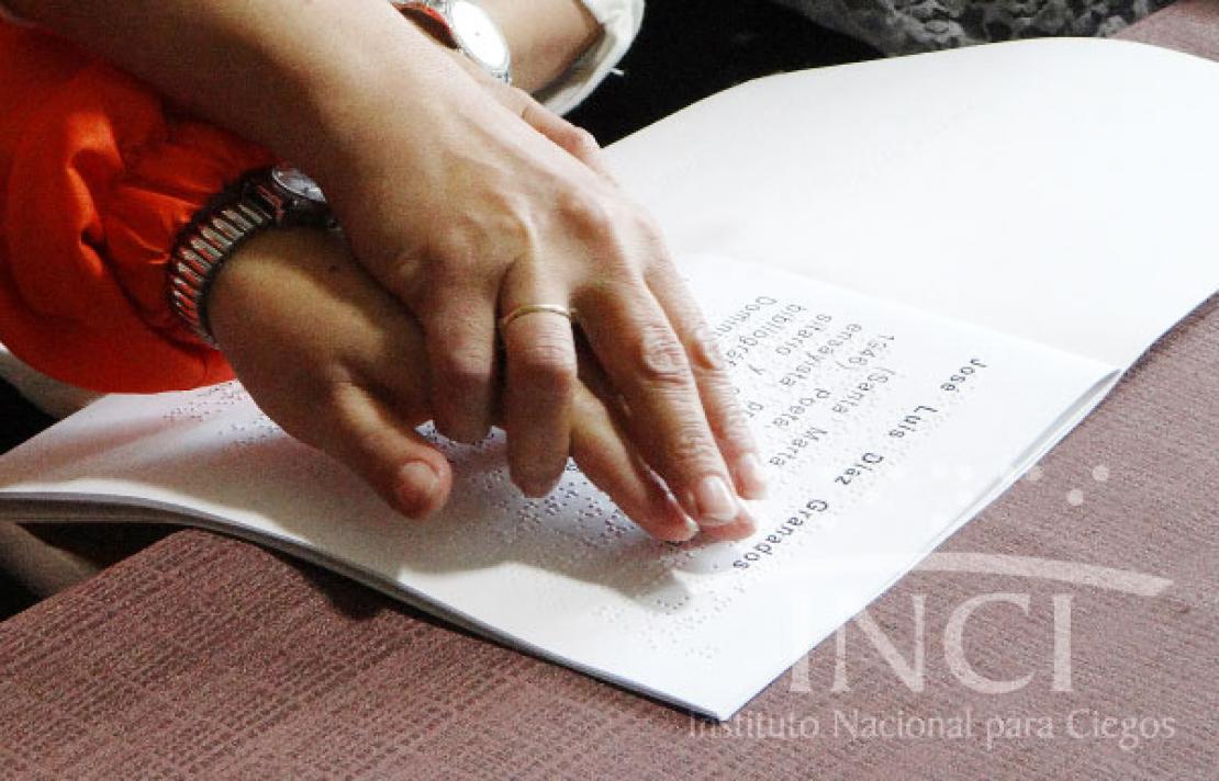 Imagen, manos leyendo braille