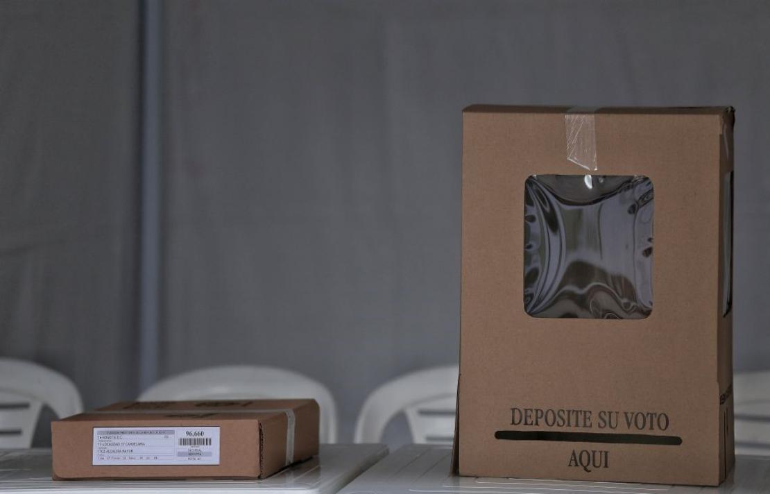 Foto, una mesa de votación con una urna donde los votantes depositan los tarjetones de votación