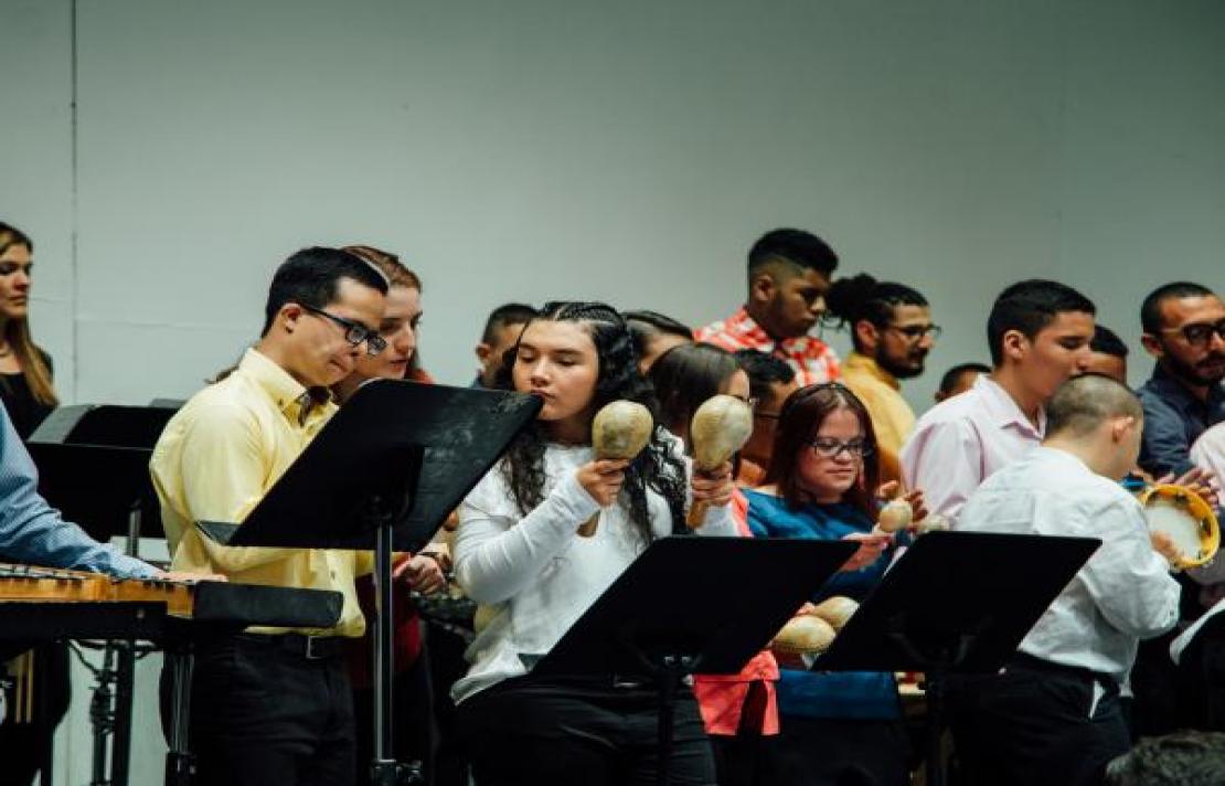 En la foto, personas con discapacidad interactuando con instrumentos musicales