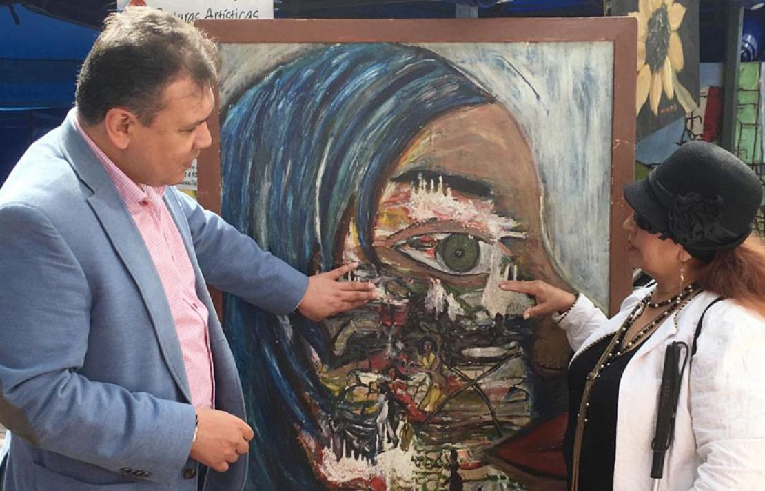 Director Carlos Parra Dussan, tocando una pintura en oleo