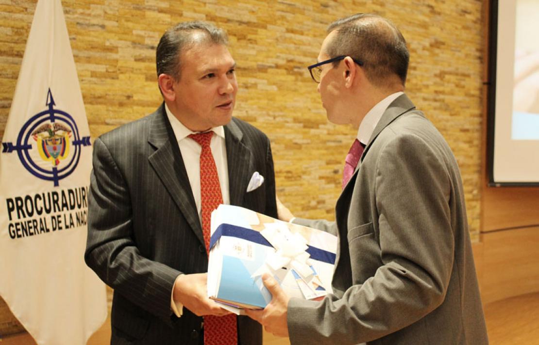 Fotografía, Carlos parra dussan recibiendo de parte de la procuraduria la ley 1712 en braille