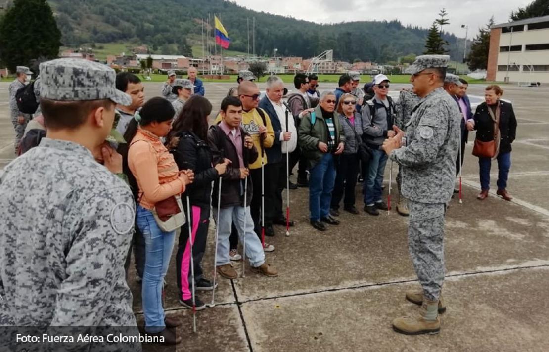 Personal de la fuerza aérea recibiendo a las personas con discapacidad visual