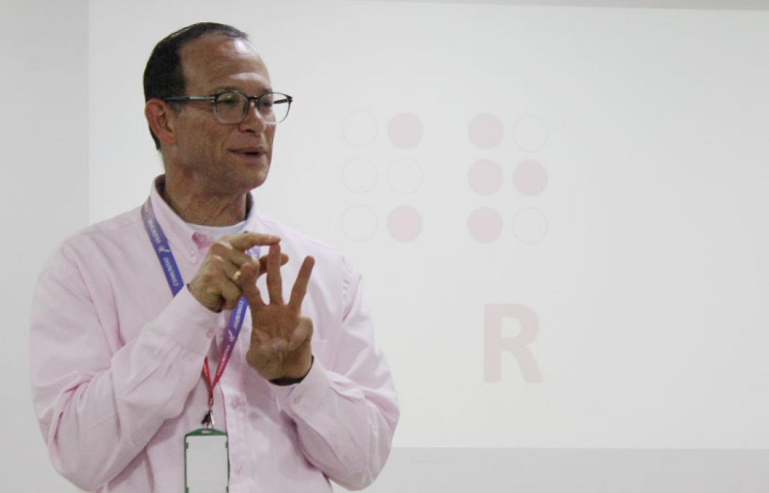 Enrique King, frente al auditorio dictando el taller de braille