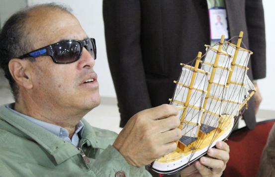 Fotografía, Persona con discapacidad visual con un modelo a escala de un barco