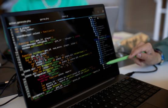 Diseñadores web analizando en un computador portátil el codigo de programación de un sitio web